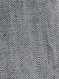 A close-up view of a woven fabric texture featuring a dense pattern of interlaced threads. The fabric appears sturdy and thick, with a prominent diagonal weave pattern, indicative of denim material.