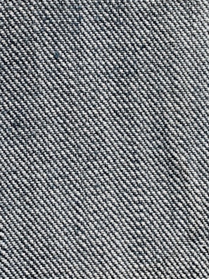 A close-up view of a woven fabric texture featuring a dense pattern of interlaced threads. The fabric appears sturdy and thick, with a prominent diagonal weave pattern, indicative of denim material.