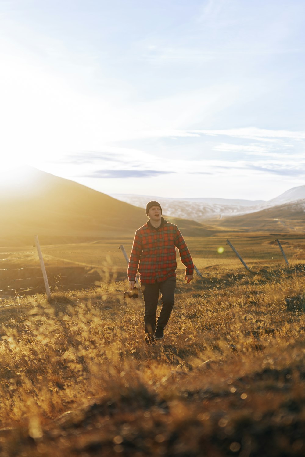 Ein Mann läuft durch ein Feld mit Bergen im Hintergrund