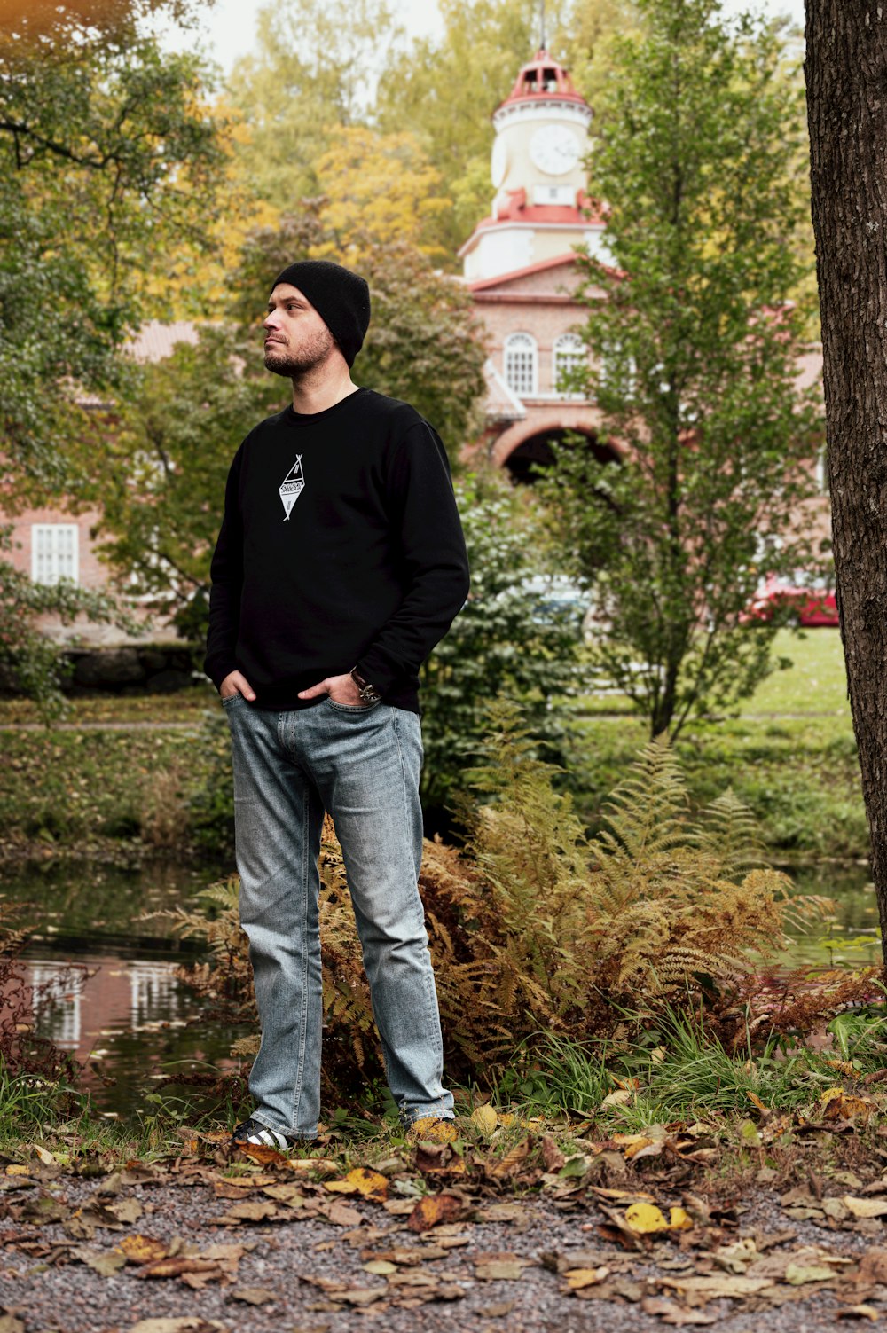 a man standing next to a tree in a park