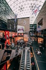 a shopping mall with people walking up and down the escalator