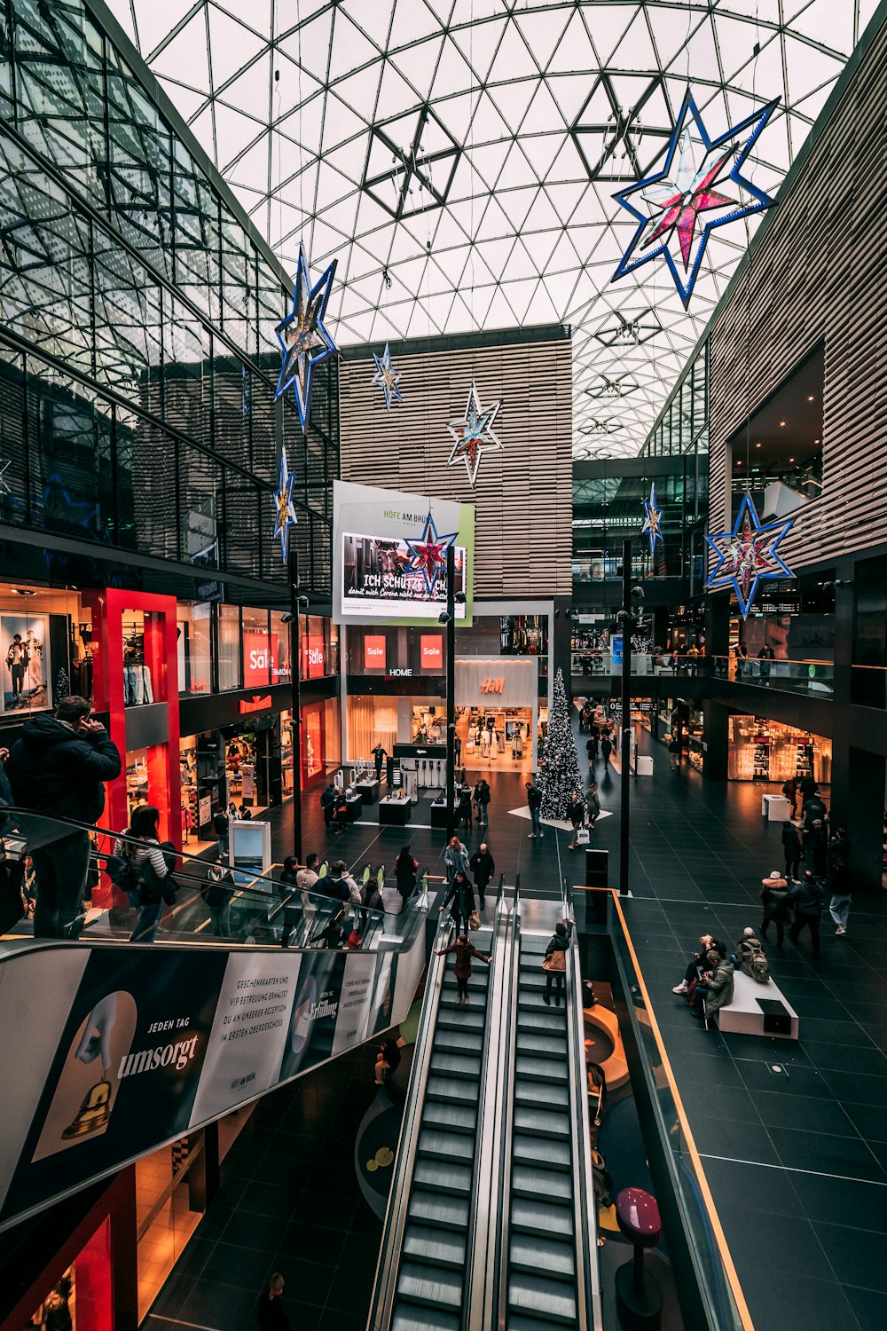 a shopping mall with people walking up and down the escalator