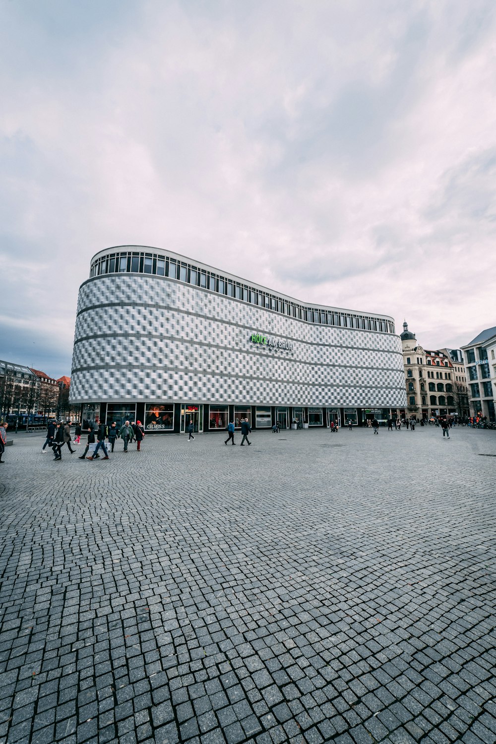 ein großes Gebäude mit vielen Leuten, die um es herum laufen