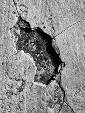 a black and white photo of a crack in a rock