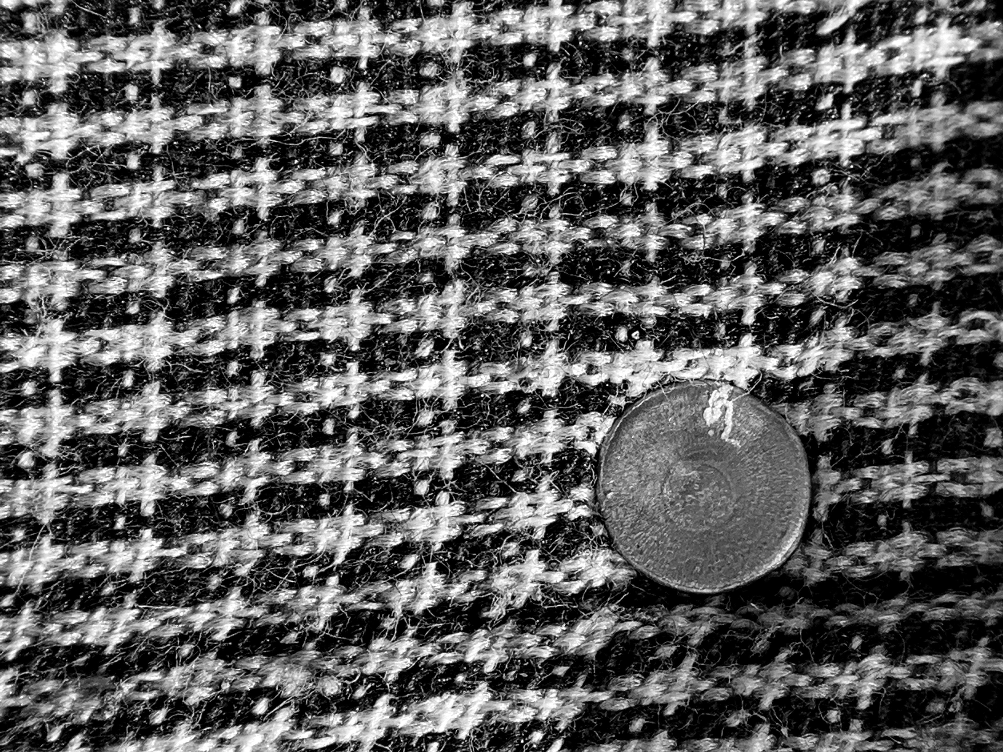 a black and white photo of a button on a jacket
