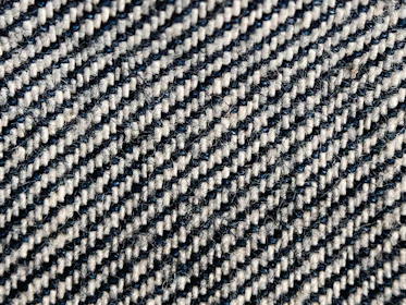 Close-up of black and white streetwear fabric texture with sharp, clean lines.