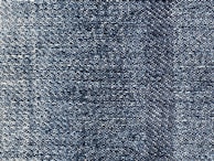 A close-up view of blue denim fabric, showcasing the intricate weave pattern and texture of the material.