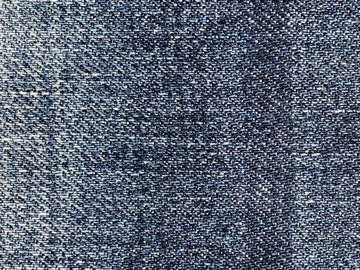 Close-up shot of rich indigo Japanese denim fabric, highlighting its textured weave and deep color.