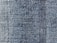 A close-up view of blue denim fabric, showcasing the intricate weave pattern and texture of the material.