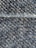 A close-up view of a textured fabric with interwoven dark blue and beige threads, creating a detailed woven pattern. The fibers appear slightly fuzzy, indicating a tightly woven, rough textile.