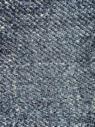 Close-up view of a textured denim fabric, showcasing a weave of blue and white threads.