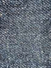 Close-up view of a textured denim fabric, showcasing a weave of blue and white threads.