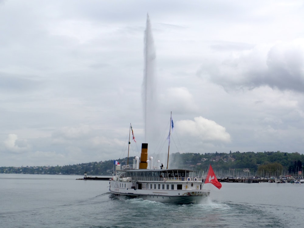 a large white boat in the water with a lot of smoke coming out of it