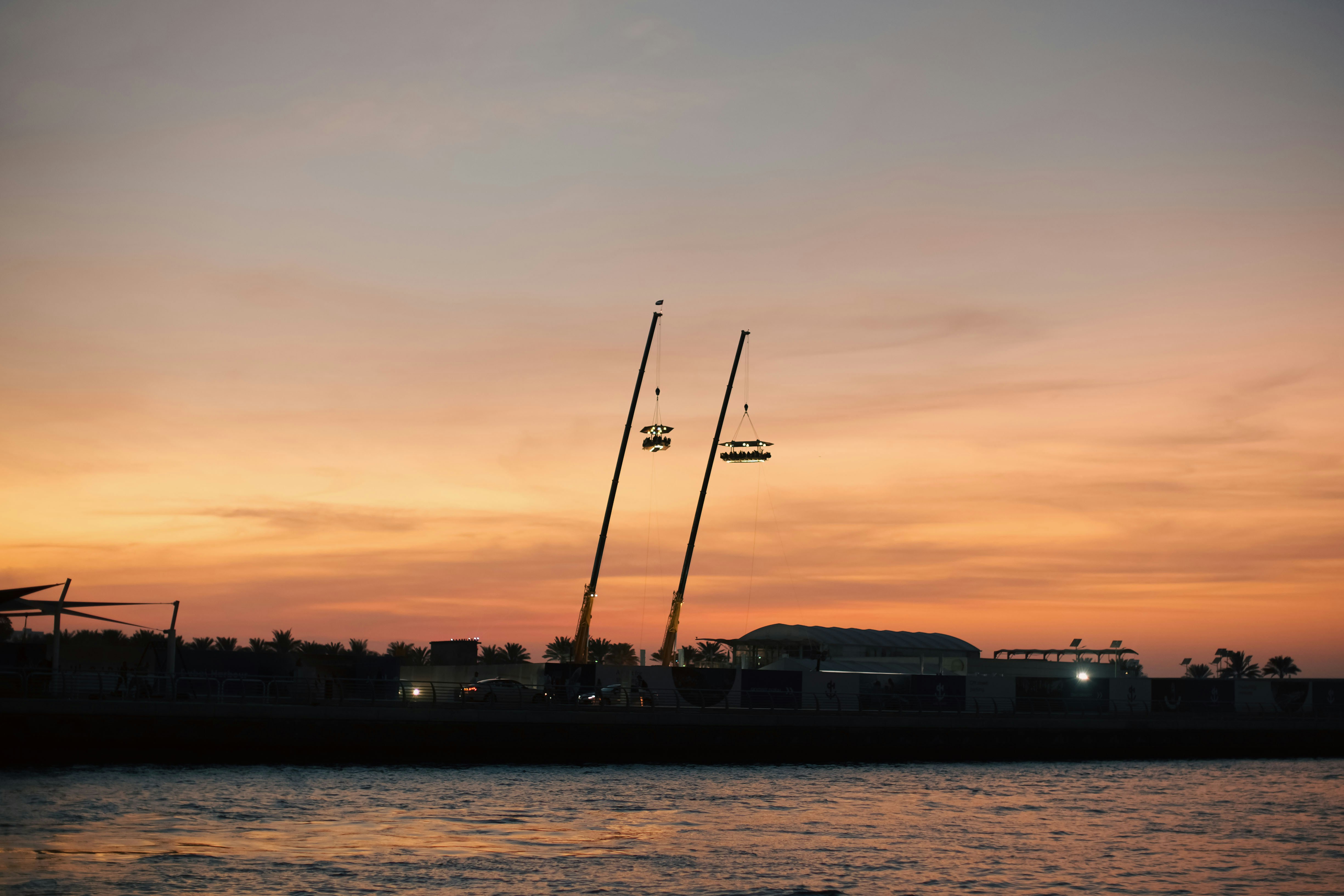 the sun is setting over the water and a boat is in the water