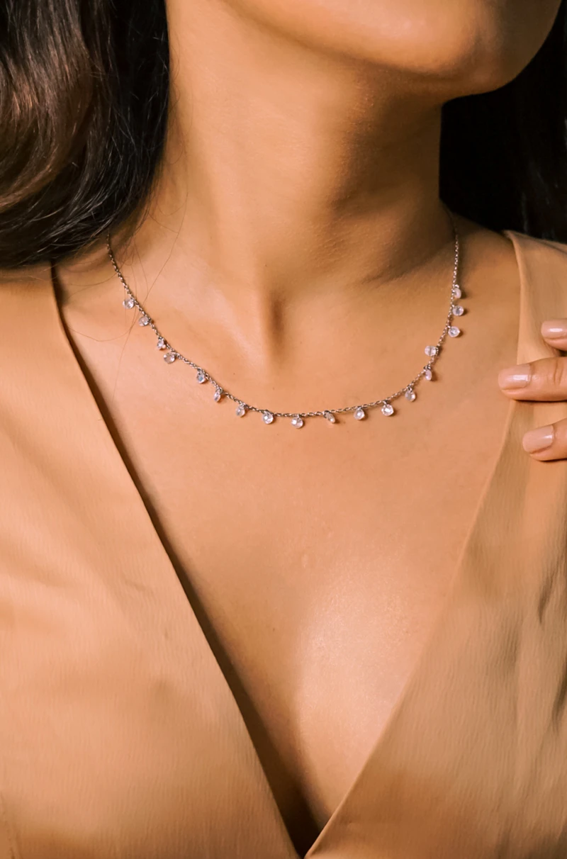 Close view of an adult woman's collarbone wearing a fine diamond necklace
