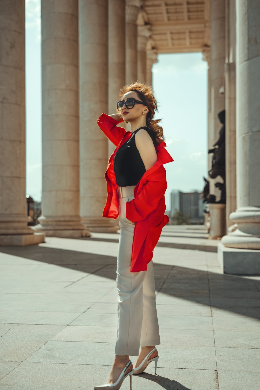 a woman in a black top and white pants