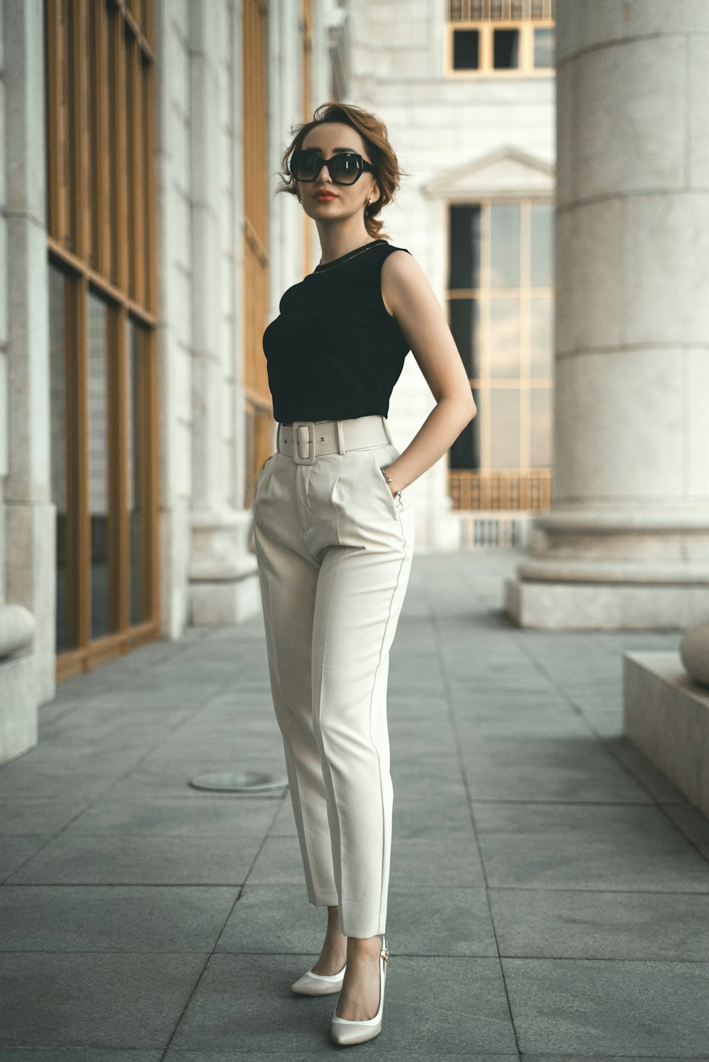 a woman in a black top and white pants