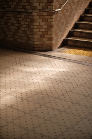 a tiled floor with a stair case in the background