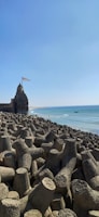 a large rock formation on a beach next to the ocean