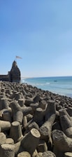 a large rock formation on a beach next to the ocean