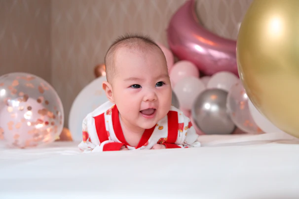 A playful boy wearing a cool striped outfit, laughing while holding colorful balloons.