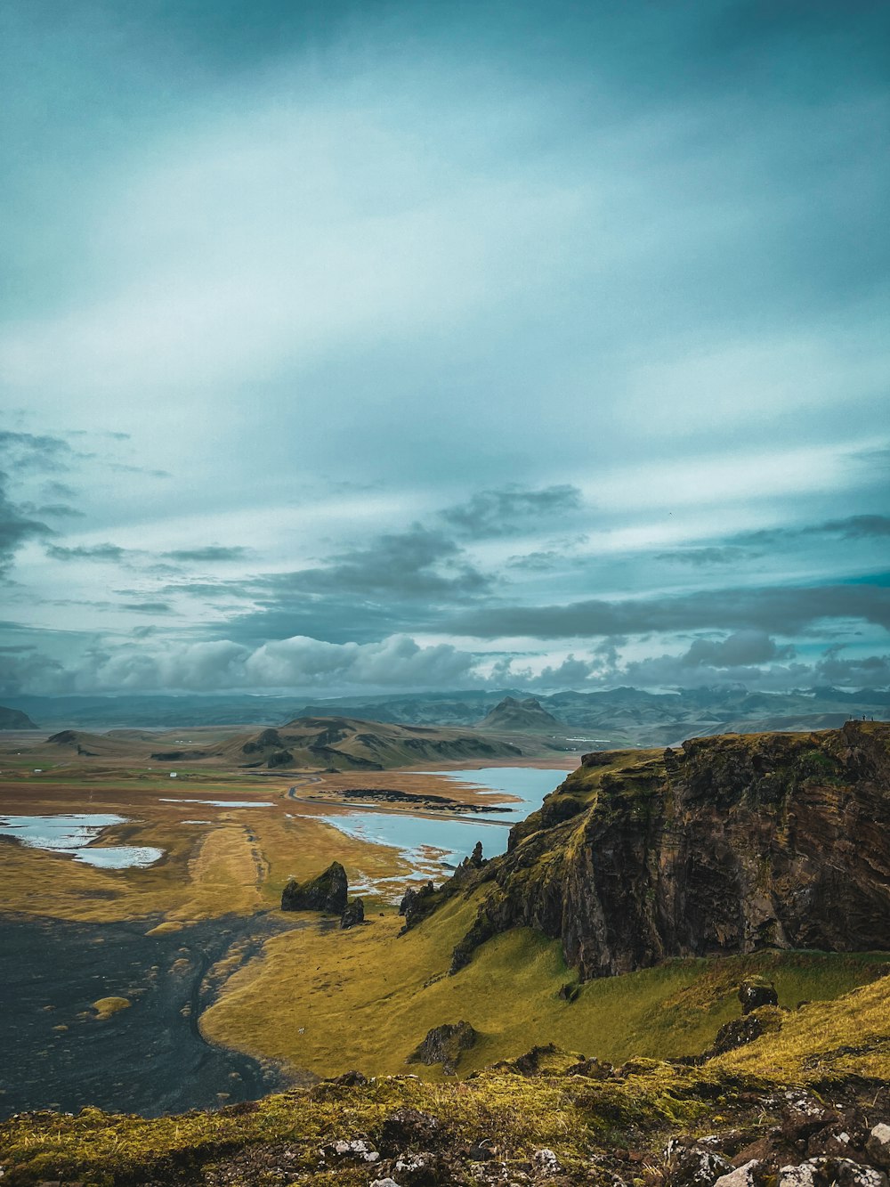 a large body of water sitting on top of a lush green hillside