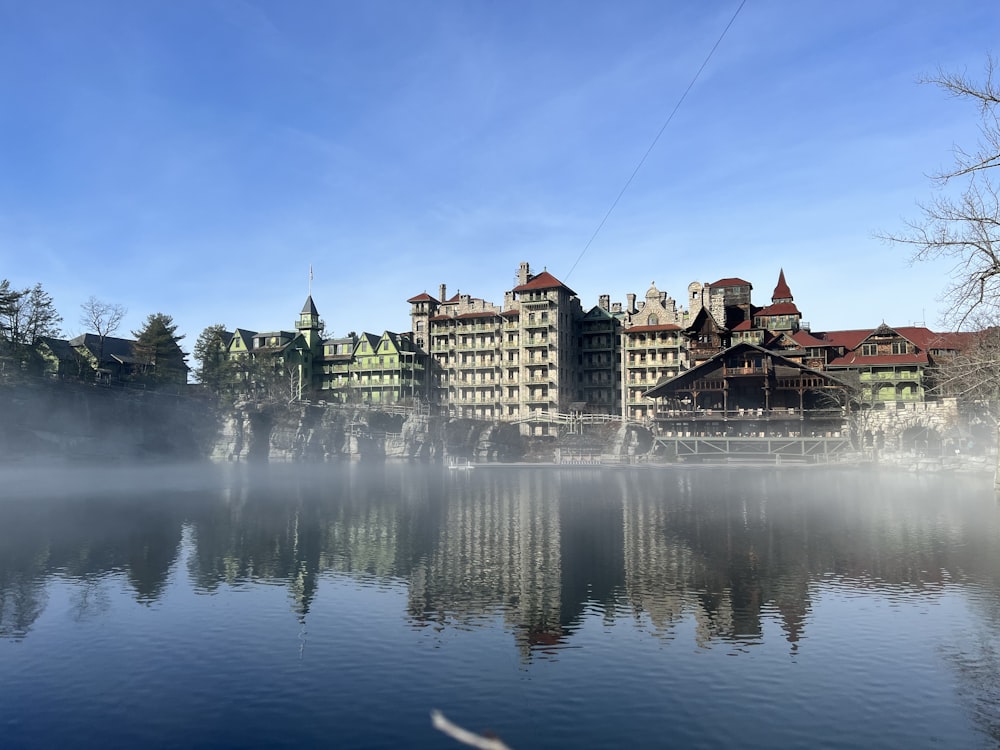 Un grande edificio seduto sulla cima di un lago vicino a una foresta