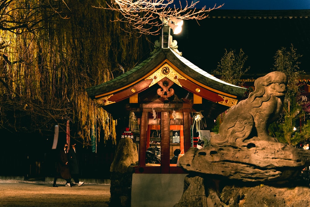 a small building with a statue in front of it