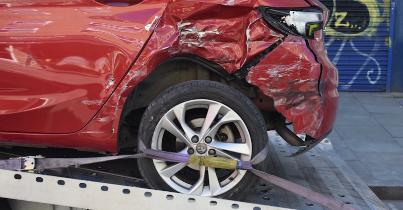 a red car is on a flatbed tow truck