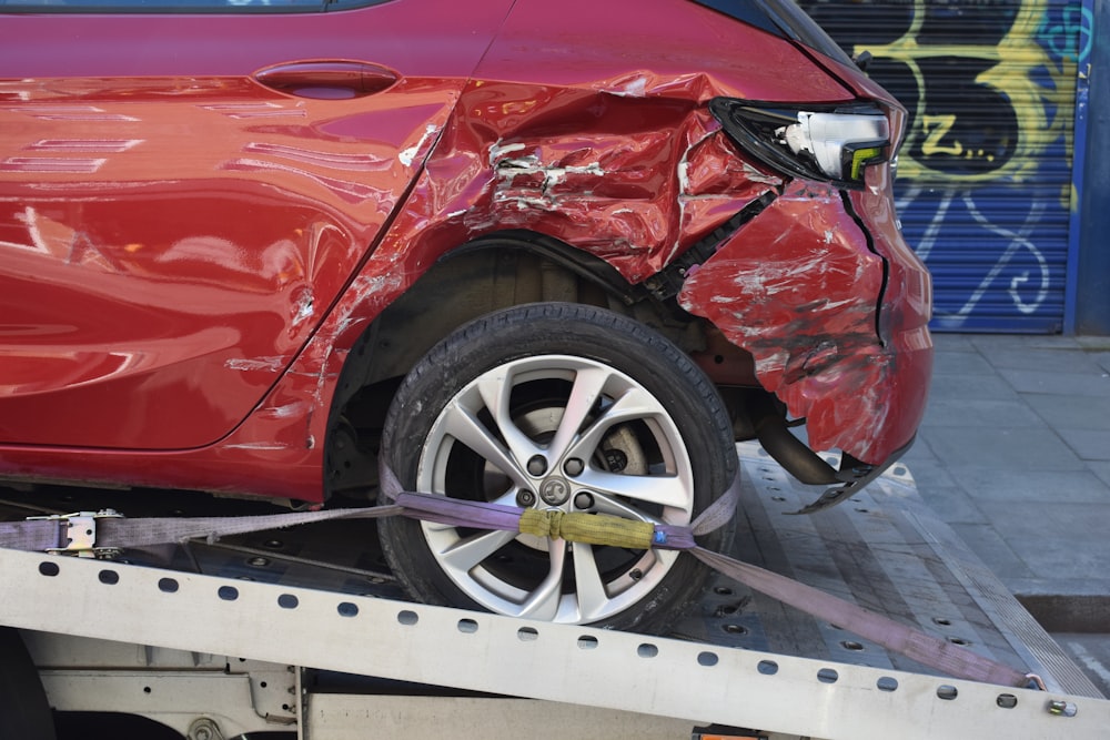 a red car is on a flatbed tow truck