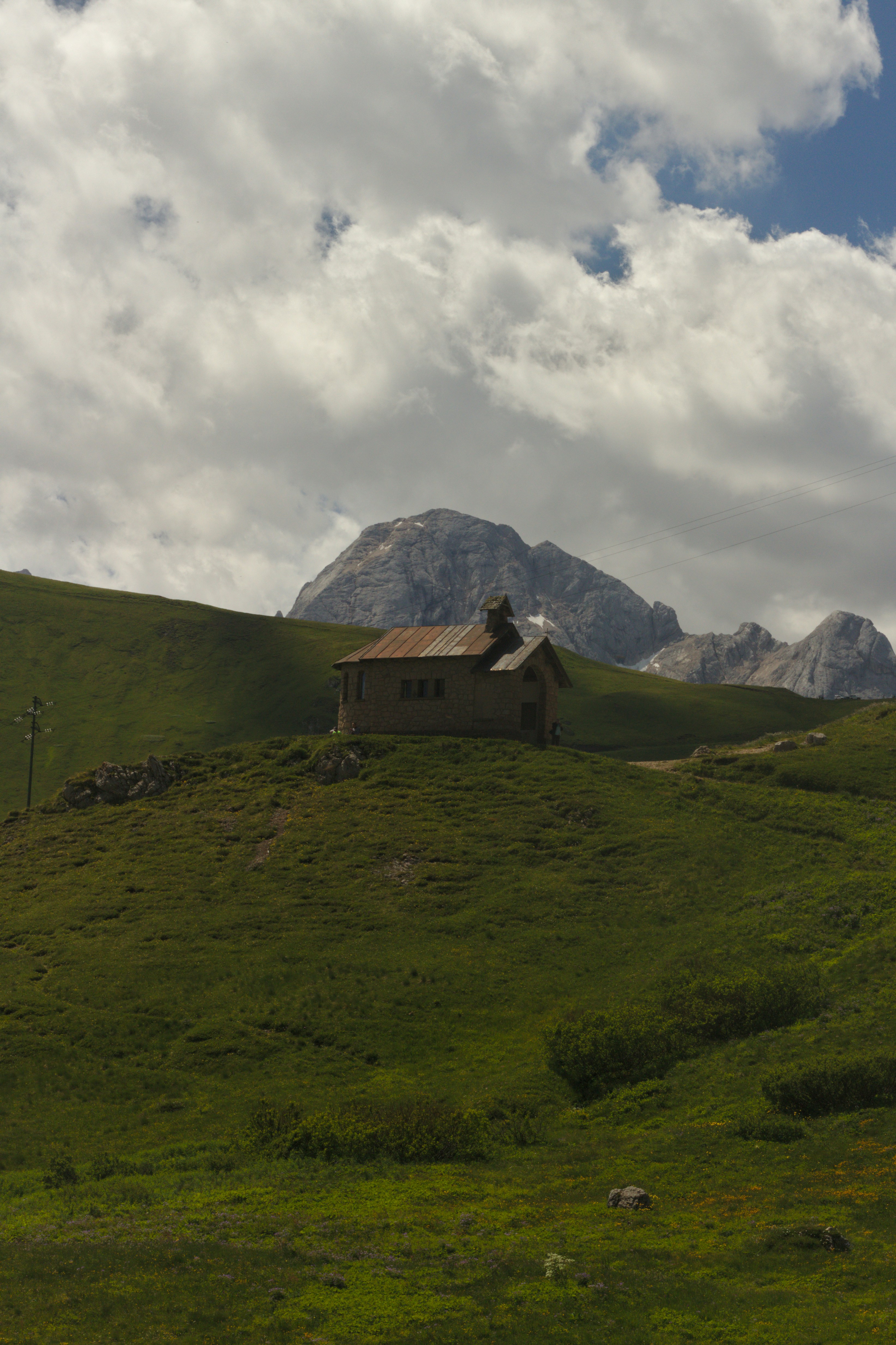 une maison sur une colline avec des montagnes en arrière-plan