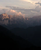 A vibrant mountain scene capturing the play of light and shadow in acrylic.