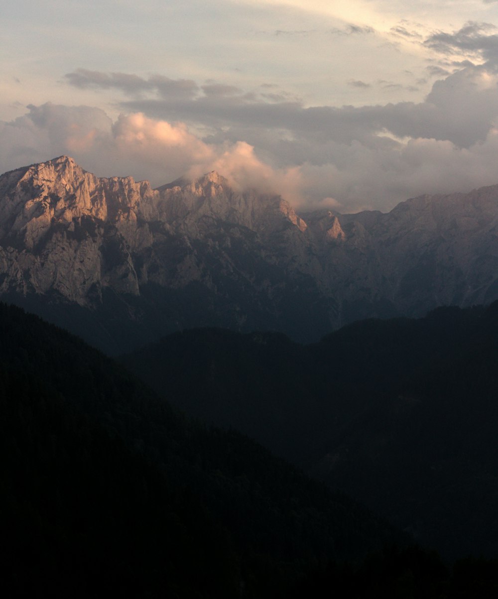 a view of a mountain range with clouds in the sky