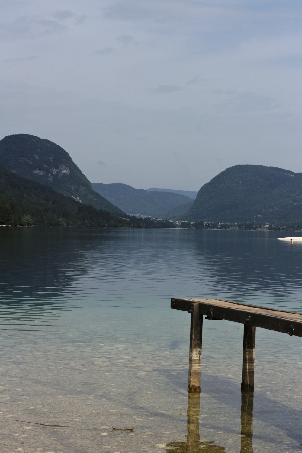 a wooden bench sitting in the middle of a lake