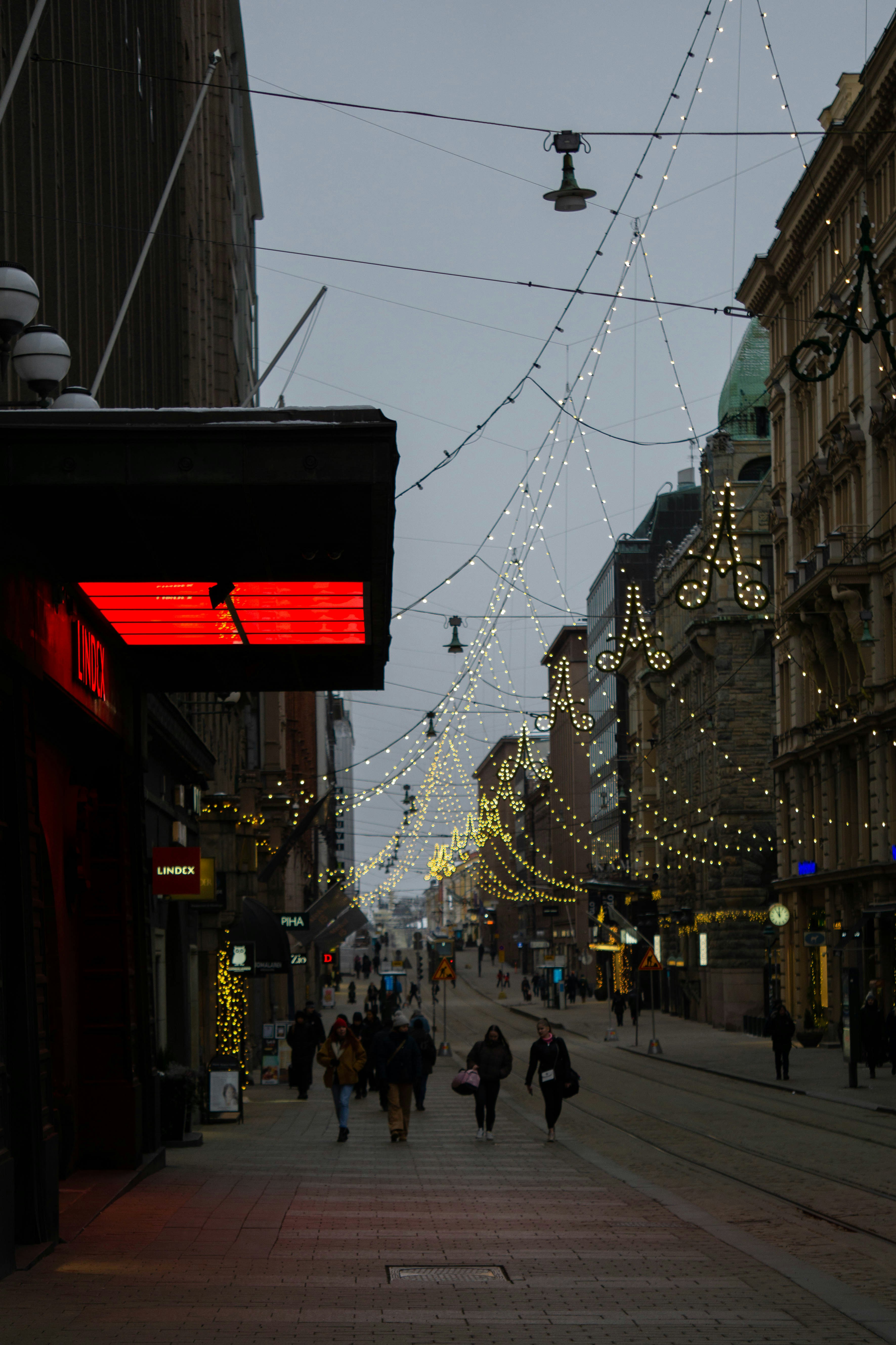 a city street with a lot of people walking down it