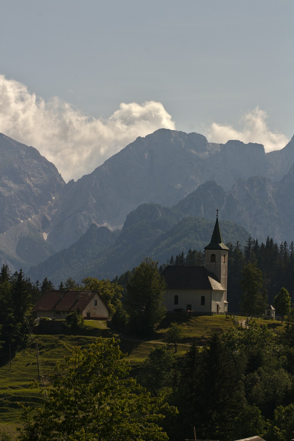 a church on a hill with mountains in the background