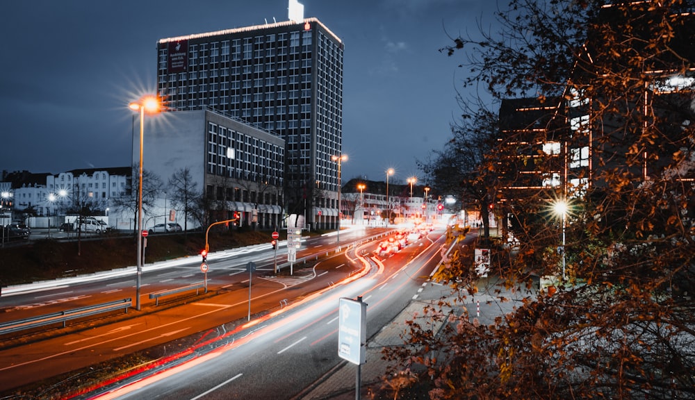 a city street at night with a building in the background