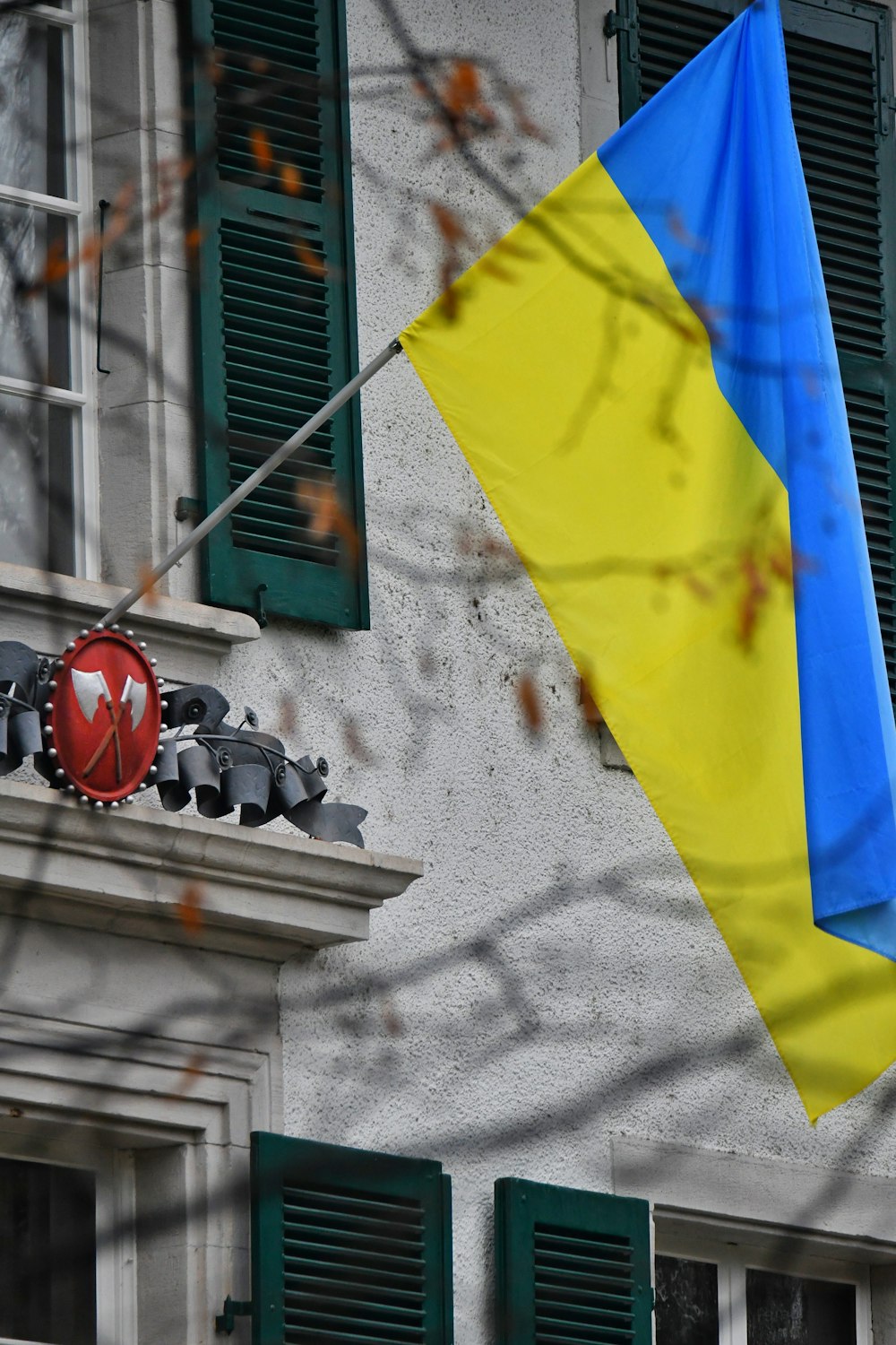 a blue and yellow flag hanging from the side of a building