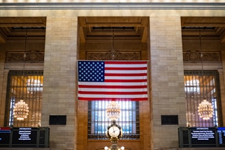 a large american flag hanging from the side of a building