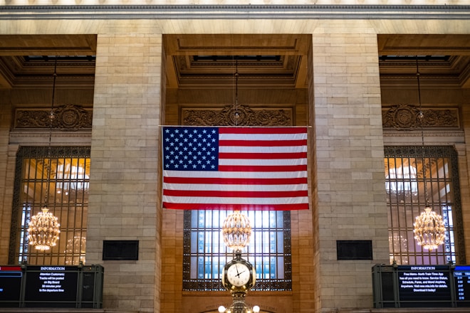 a large american flag hanging from the side of a building