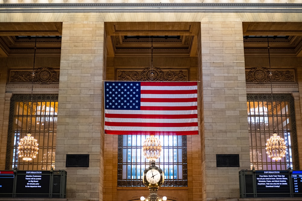 a large american flag hanging from the side of a building