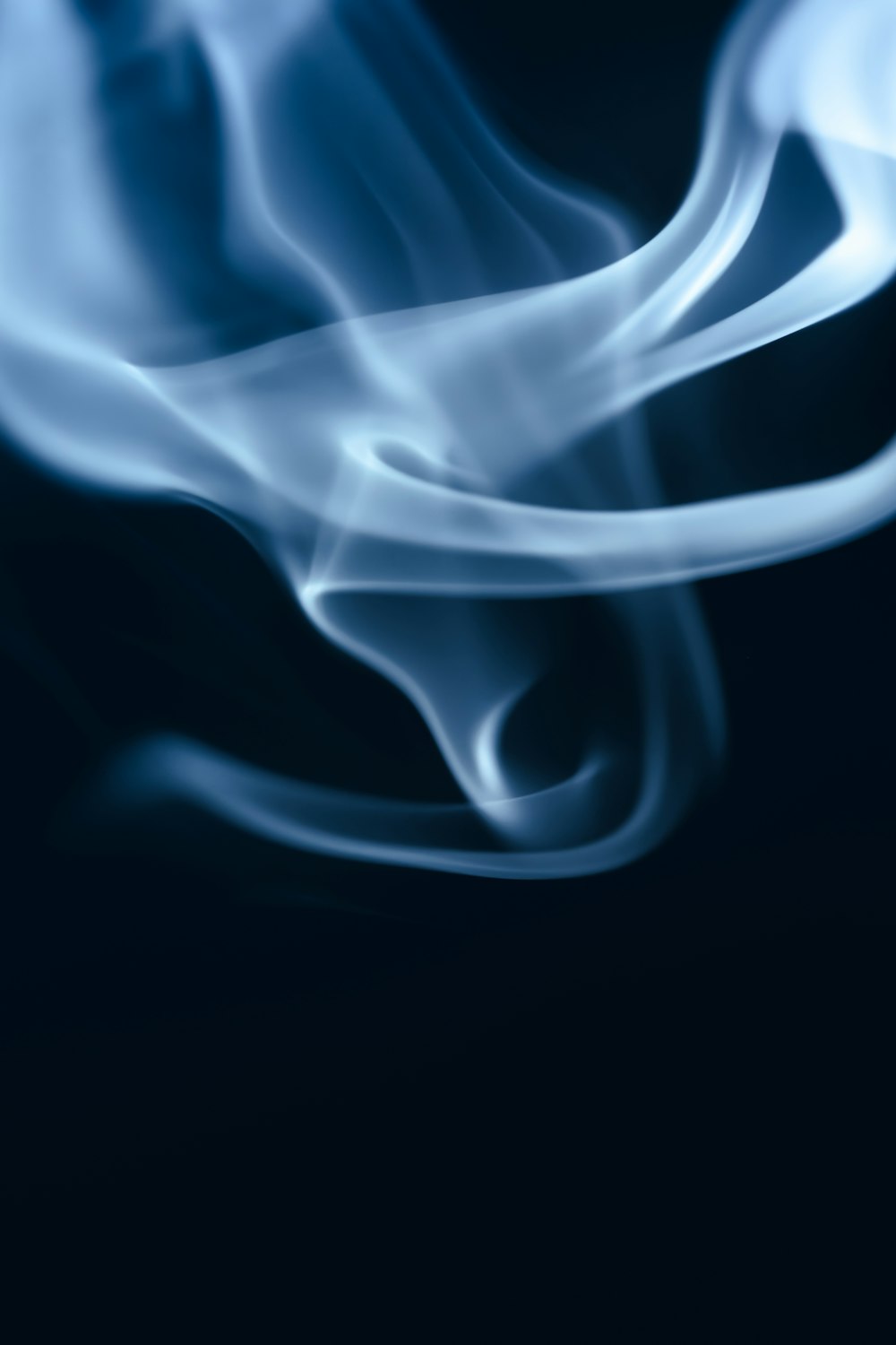 a blurry photo of blue smoke on a black background