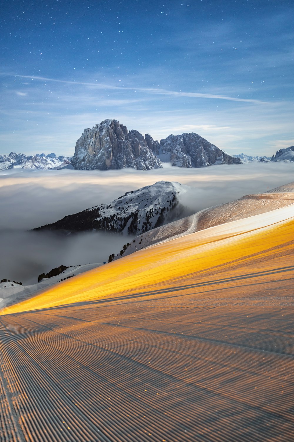 a snow covered mountain range under a blue sky