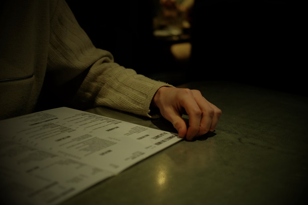 a person's hand resting on a piece of paper