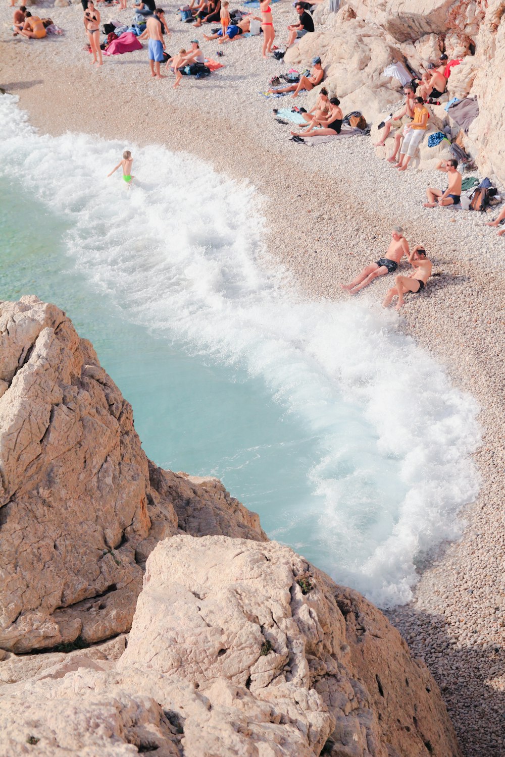 a group of people laying on top of a beach next to the ocean