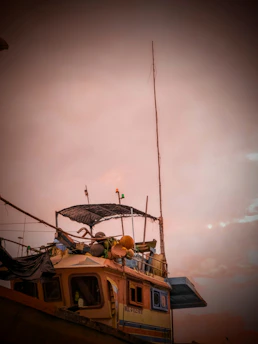 A cozy fishing boat at dawn with green and black fishing gear neatly arranged.