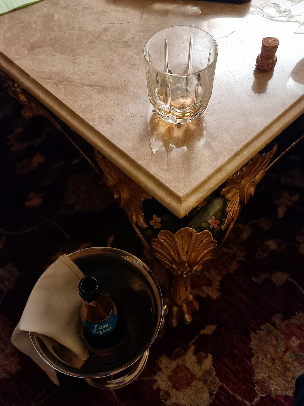 a table with a wine glass and a bottle on it