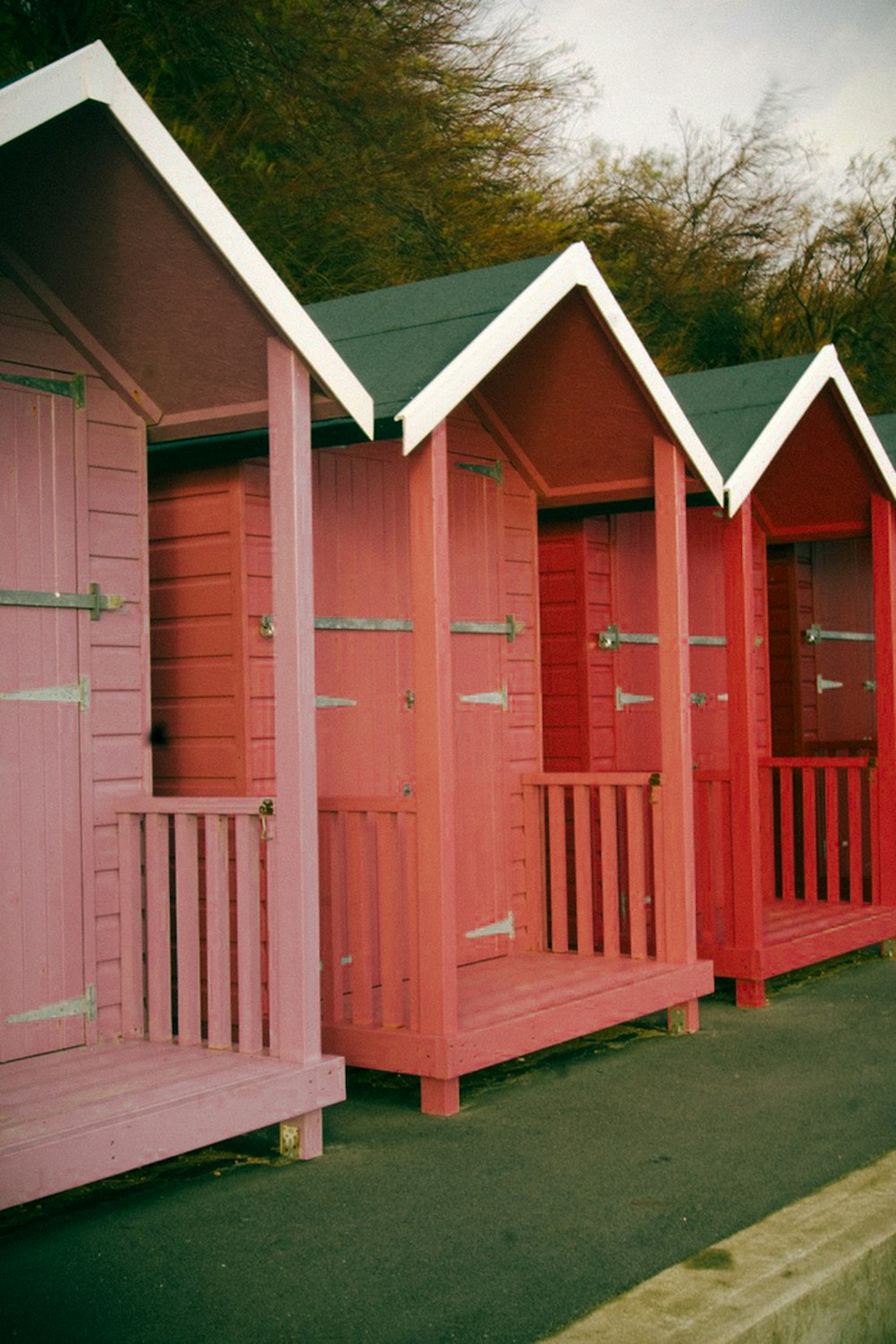 a row of pink beach huts sitting next to each other