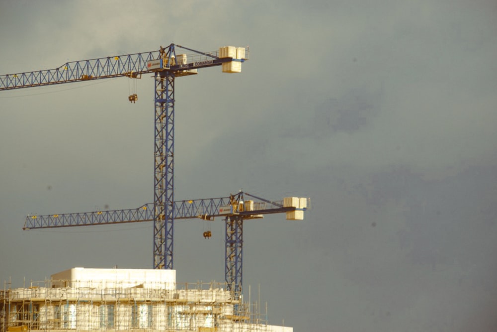 a large crane sitting on top of a building under a cloudy sky