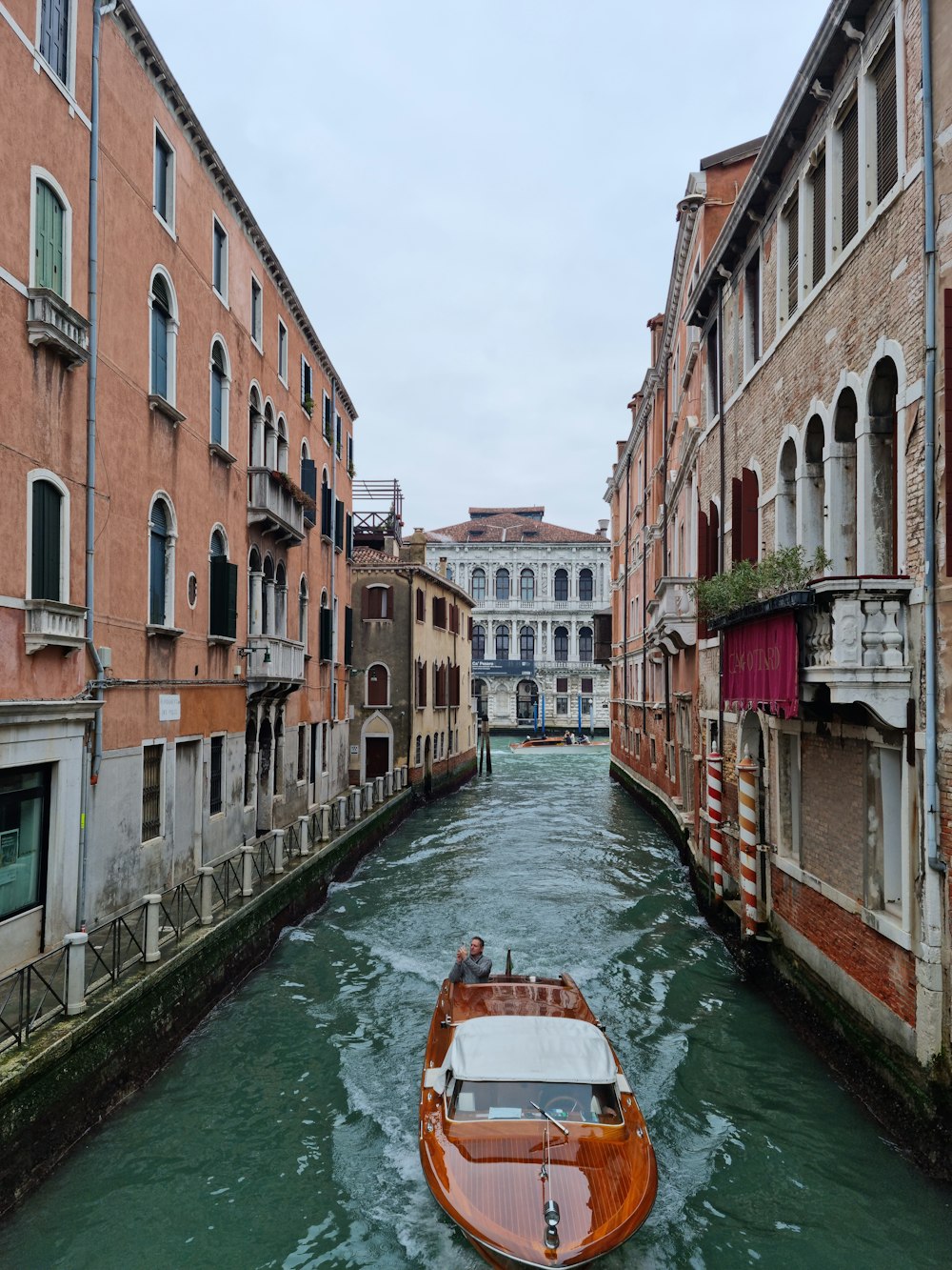 a boat traveling down a narrow canal in a city